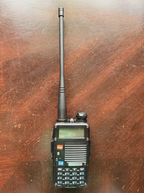 baofeng btech bf f8hp front view with black antenna attached black textured body single control knob lcd display numeric keypad speaker grille