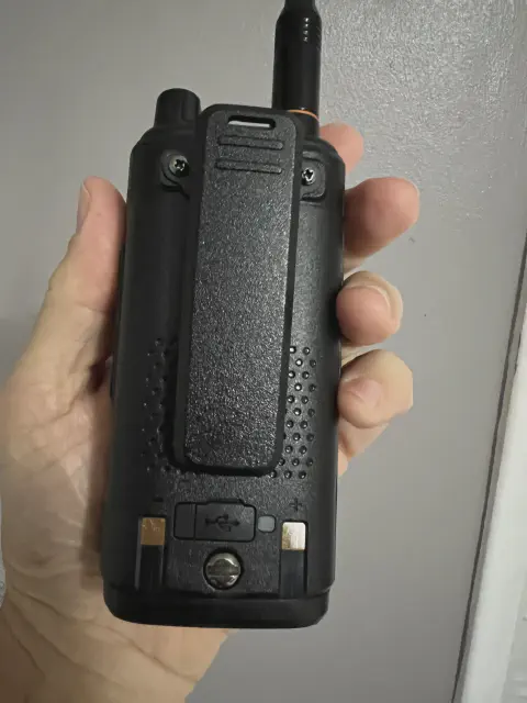 baofeng btech uv 17r plus back view showing belt clip rubber covered usb port and charging metal terminals black textured body