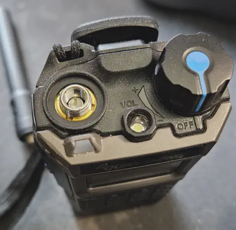quansheng uv k1 top view showing sma m connector without antenna grey and black textured body single control knob led flashlight