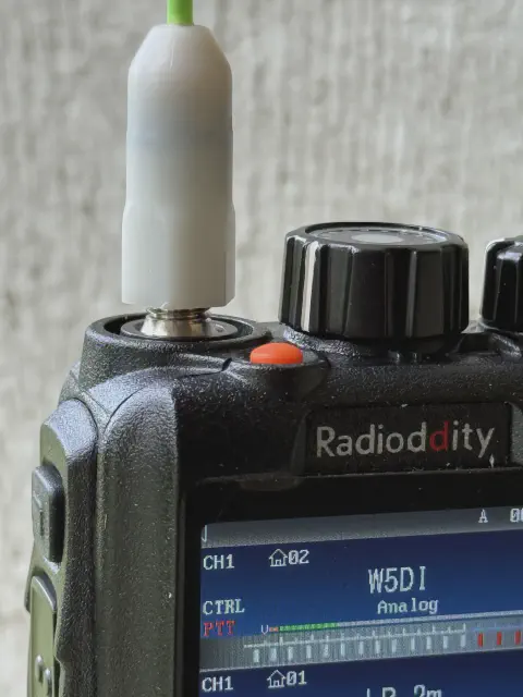 radioddity gd 88 front top close up view with green sma m signal stick antenna attached showing gap at antenna connector black textured body two control knobs partial lcd display