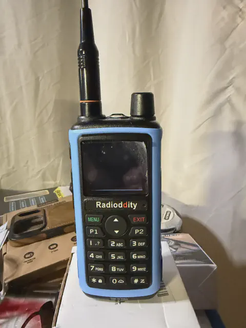 radioddity gm 30 front view with antenna attached blue and black textured body single control knob lcd display numeric keypad