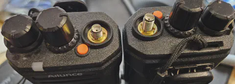 retevis ailunce ha1g top view two radios side by side with different sma m connector thread lengths showing sma f connector without antenna black textured body two control knobs