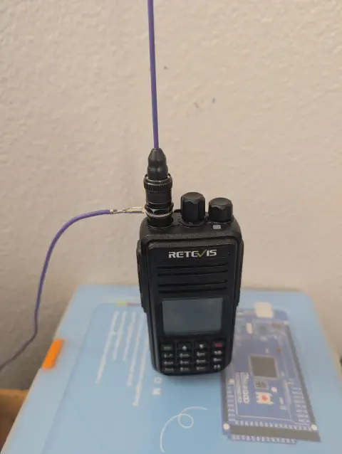 retevis ailunce rt3s front view with purple signal stick antenna and purple signal strand counterpoise attached black textured body two control knobs speaker grille lcd display numeric keypad