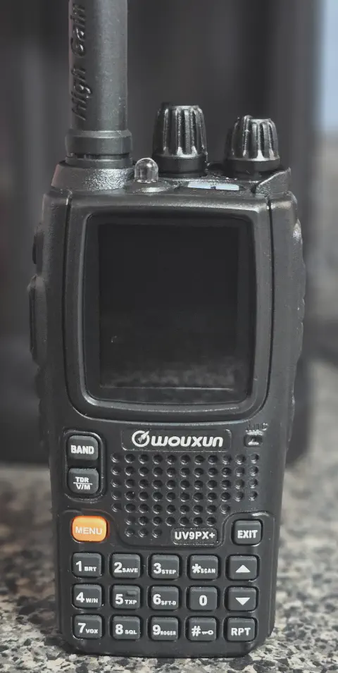 wouxun kg uv9px front view with black antenna attached black textured body two control knobs lcd display numeric keypad